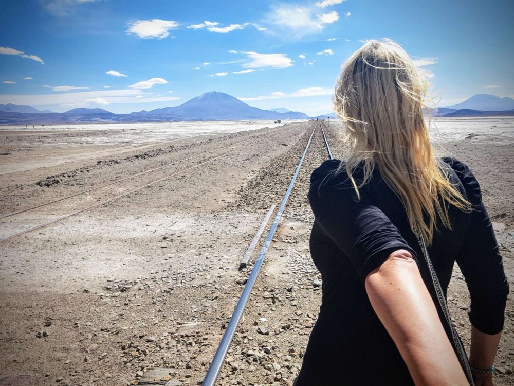 The Salar de Uyuni in Bolivia with Fernwehsarah walking along railroad tracks