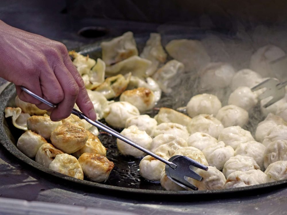 Dumplings sizzling in pan