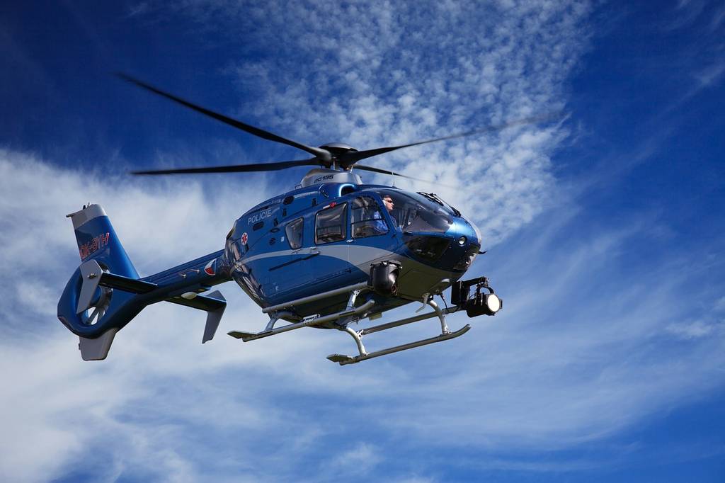 Helicopter flying in front of blue sky