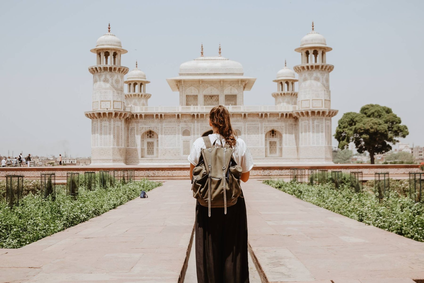 Girl with backpack walking in India - hopefully covered by the best travel insurance for backpackers!