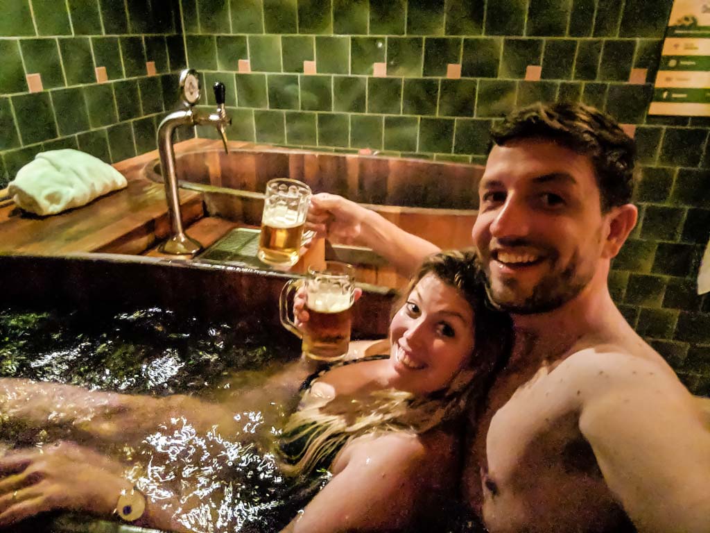 A super noisy pic of Sarah and Markus in the tub with two beers