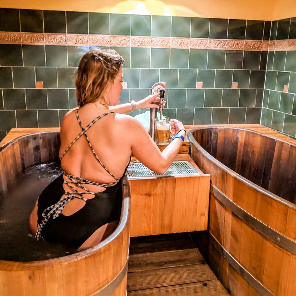 Sarah tapping a beer while in the tub