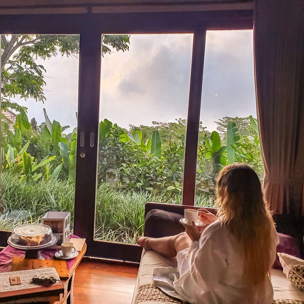 Sarah drinking a coffee on the lounge of the one bedroom villa