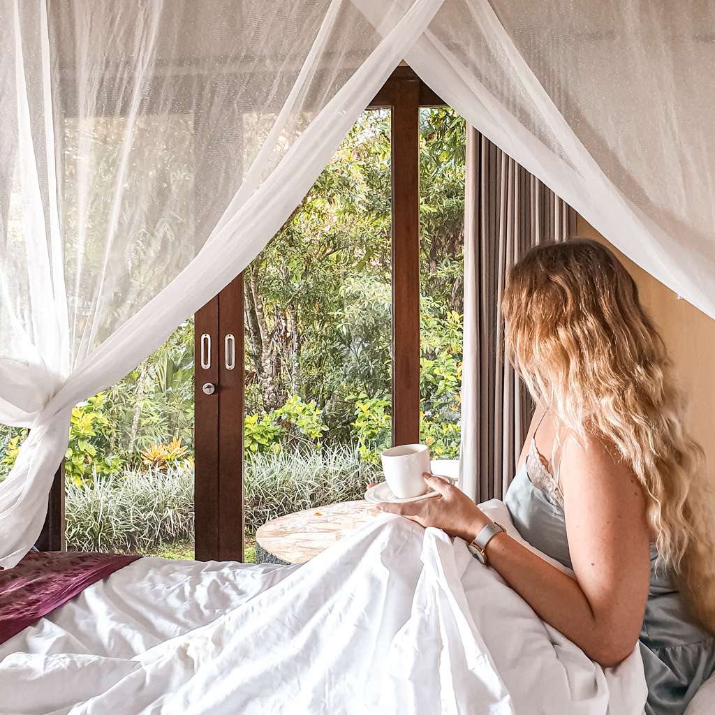 Sarah drinking a coffee in bed