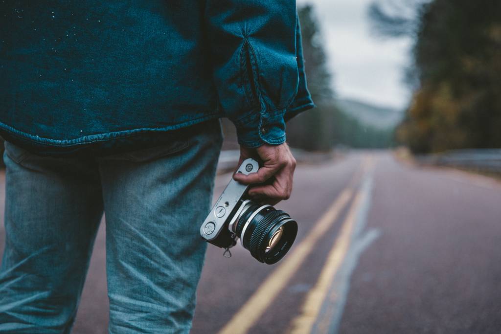 Man holding a mirrorless camera for Instagram