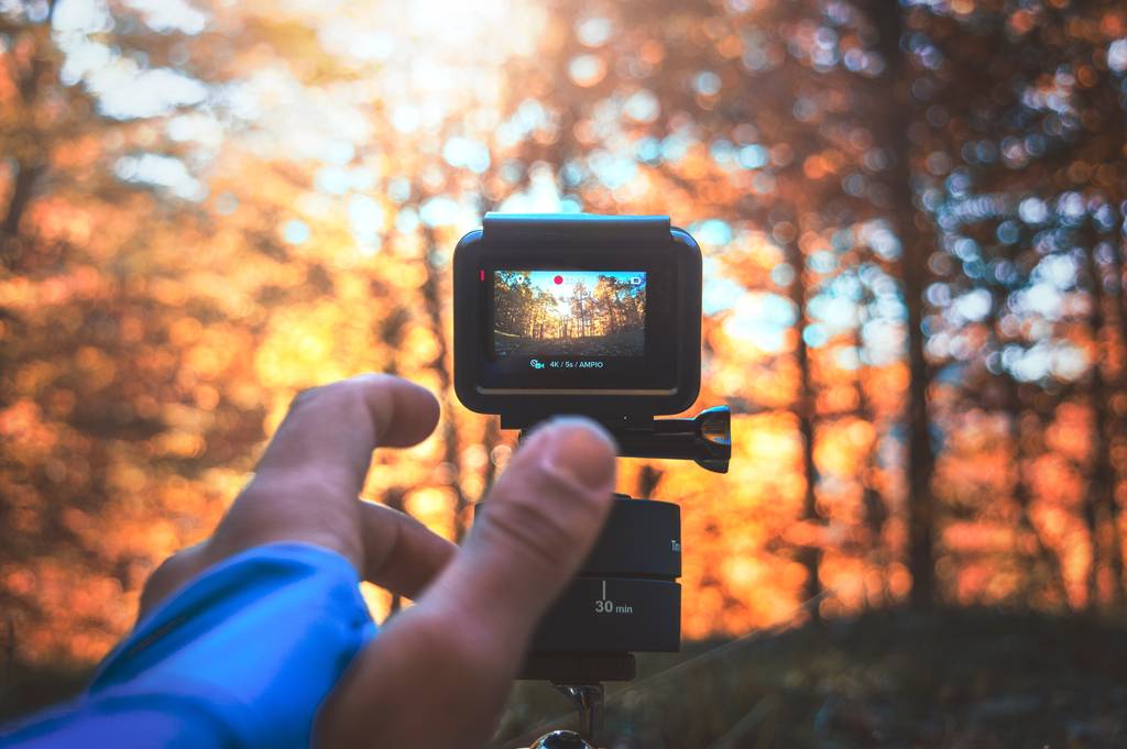 Man filming a forest with a GoPro - one of the best cameras for travel bloggers