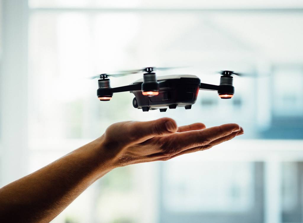 Drone landing on man's hand - one of the best cameras for travel bloggers