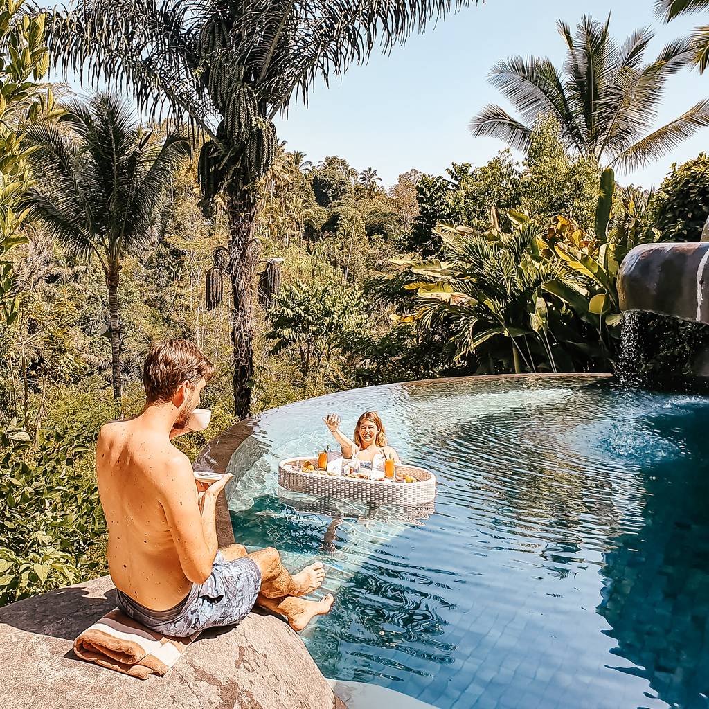 Sarah and Markus enjoying a floating afternoon tea in the pool at Padma Resort Ubud - one of the best resorts in Bali for honeymoon couples