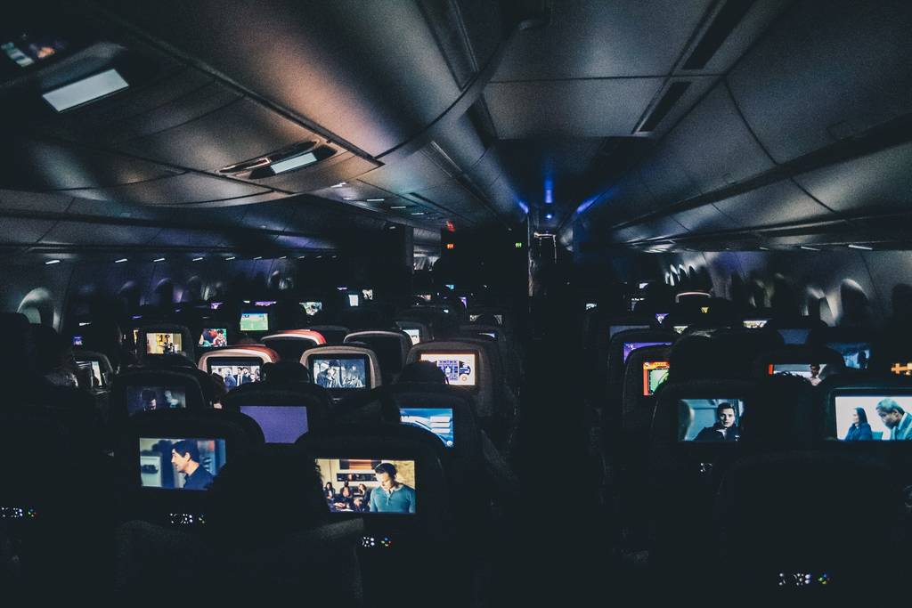Economy Class plane with inflight entertainment screens - travel essentials for long haul flights